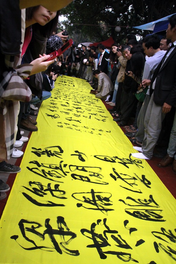 Bức thư pháp khổng lồ được viết ngay trên vỉa hè đi bộ của Văn Miếu thu hút rất đông người xem